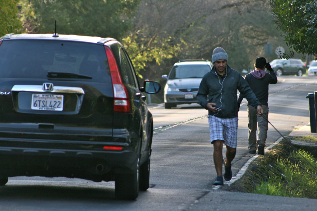 Neighbors dodge cars and other pedestrians alike along Walnut Boulevard.